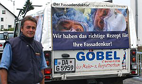 Malermeister Göbel vor seinem Auto mit Fassadenoktor-Werbung