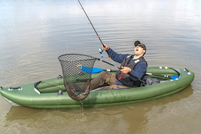Angler im Schlauchboot freut sich über Fang in Käscher