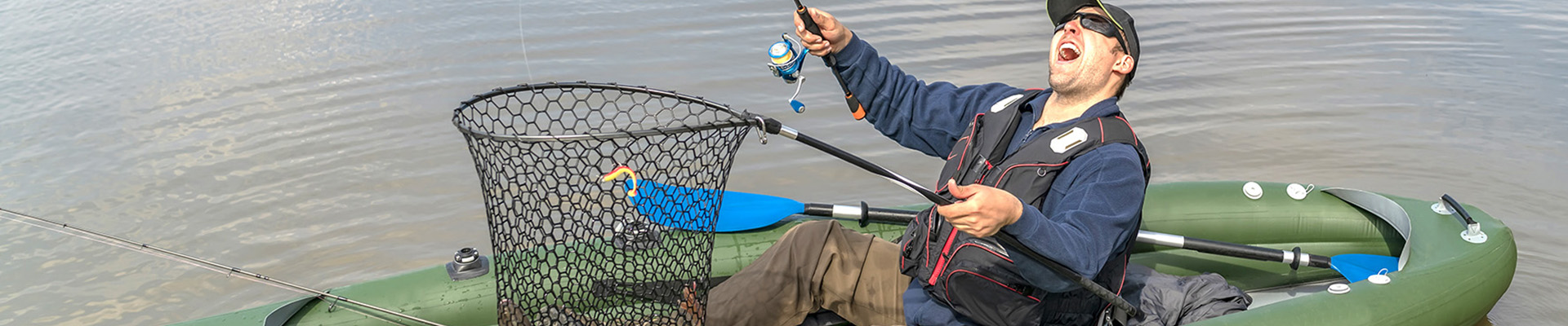 Kayak fishing. Fisherman catch pike fish on inflatable boat with fishing tackle at lake.