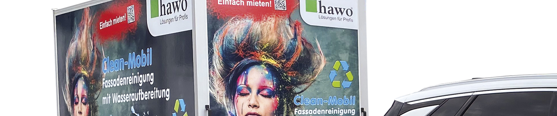 Mann dampft mit Hochdruckreiniger eine Fassade ab